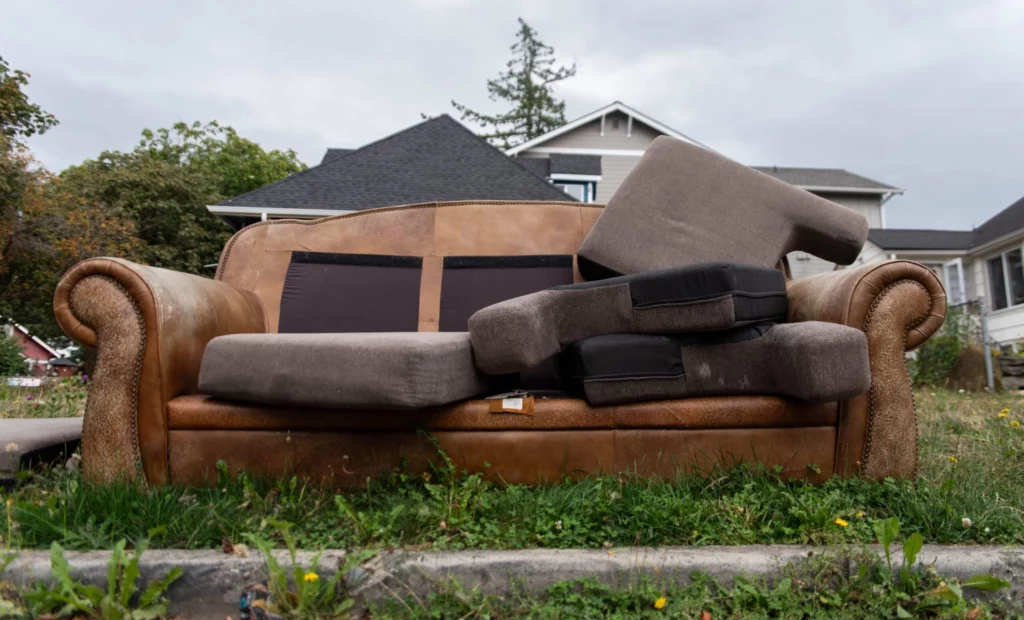 old brown couch laying on the side of the road